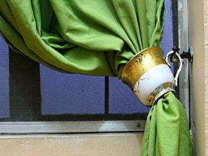 Чашка с выбитым донышком может стать оригинальным подхватом для штор. Острые края вокруг отверстия нужно обработать наждачной бумагой, чтобы они стали гладкими и не цеплялись за ткань. Чашка с выбитым донышком может стать оригинальным подхватом для штор. Острые края вокруг отверстия нужно обработать наждачной бумагой, чтобы они стали гладкими и не цеплялись за ткань.