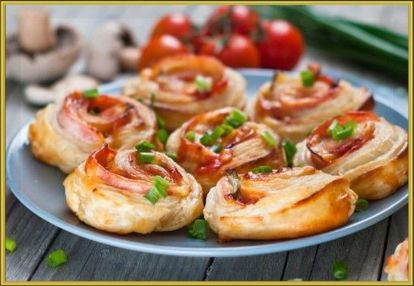 12. Рулеты с сыром и ветчиной. Раскатайте 400 г слоёного теста в прямоугольник размером примерно 30 × 45 сантиметров. Нарежьте тонкими ломтиками 200 г ветчины и 150 г твёрдого сыра. Порубите зелень и чеснок, смешайте их с 1–2 столовыми ложками майонеза и намажьте этим соусом пласт теста, отступив 3–5 сантиметров от края. Равномерно разложите по тесту ветчину и сыр. Несмазанный край оставьте свободным. Сверните рулет так, чтобы эта полоска теста оказалась с внешней стороны. Её можно смочить водой, чтобы плотно запечатать рулет. Разрежьте рулет на куски шириной 4–6 сантиметров. Сверху рулет можно смазать желтком и посыпать маком или кунжутом. Выпекайте 20–25 минут при 180 °С. 12. Рулеты с сыром и ветчиной. Раскатайте 400 г слоёного теста в прямоугольник размером примерно 30 × 45 сантиметров. Нарежьте тонкими ломтиками 200 г ветчины и 150 г твёрдого сыра. Порубите зелень и чеснок, смешайте их с 1–2 столовыми ложками майонеза и намажьте этим соусом пласт теста, отступив 3–5 сантиметров от края. Равномерно разложите по тесту ветчину и сыр. Несмазанный край оставьте свободным. Сверните рулет так, чтобы эта полоска теста оказалась с внешней стороны. Её можно смочить водой, чтобы плотно запечатать рулет. Разрежьте рулет на куски шириной 4–6 сантиметров. Сверху рулет можно смазать желтком и посыпать маком или кунжутом. Выпекайте 20–25 минут при 180 °С.