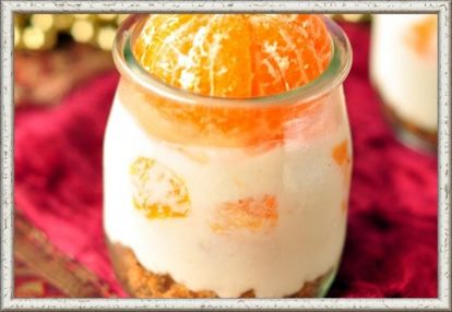 9. Мандариновый чизкейк «Аромат Рождества». Продукты: 300 г печенья, 150 г сливочного масла, 500 г творога, 200 мл сливок, 150 г сахара, 20 г желатина, 4 мандарина, 1/2 стакана сахарной пудры. Приготовление: желатин залить 150 мл холодной кипяченой воды и оставить на 1 час. Печенье измельчить и смешать с растопленным маслом, утрамбовать на дно формочек, устланных пергаментом. Охладить. Разогреть желатин до растворения. Творог со сливками взбить с сахаром. Добавить охлажденный желатин. Разложить по формочкам и поставить в холодильник. Дольки мандарина засыпать пудрой, через полчаса протушить 5–10 минут. Десерт полить соусом и украсить дольками мандарина. 9. Мандариновый чизкейк «Аромат Рождества». Продукты: 300 г печенья, 150 г сливочного масла, 500 г творога, 200 мл сливок, 150 г сахара, 20 г желатина, 4 мандарина, 1/2 стакана сахарной пудры. Приготовление: желатин залить 150 мл холодной кипяченой воды и оставить на 1 час. Печенье измельчить и смешать с растопленным маслом, утрамбовать на дно формочек, устланных пергаментом. Охладить. Разогреть желатин до растворения. Творог со сливками взбить с сахаром. Добавить охлажденный желатин. Разложить по формочкам и поставить в холодильник. Дольки мандарина засыпать пудрой, через полчаса протушить 5–10 минут. Десерт полить соусом и украсить дольками мандарина.