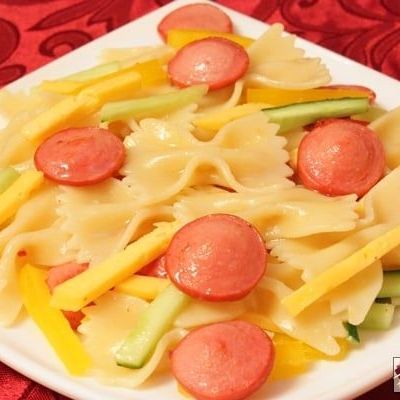 Теплый салат с макаронами Фарфалле, сосисками и овощами